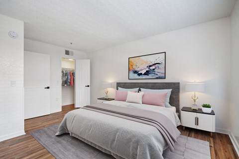 A bedroom with a large bed and a painting on the wall.