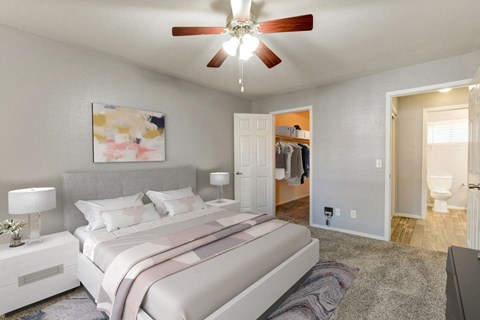 A bedroom with a large bed and a ceiling fan.