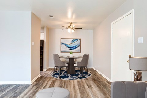 A dining room with a table and chairs.