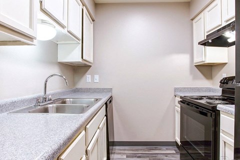 A kitchen with a black oven and a grey countertop.