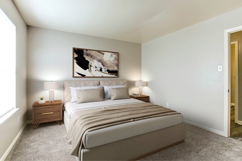 A bedroom with a large bed and a painting on the wall.