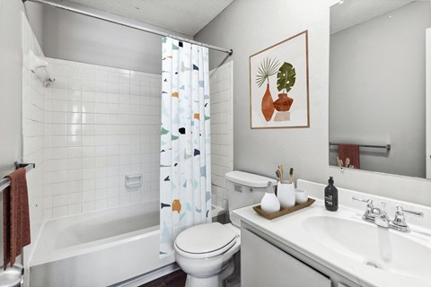 A white bathroom with a toilet, sink, and shower.