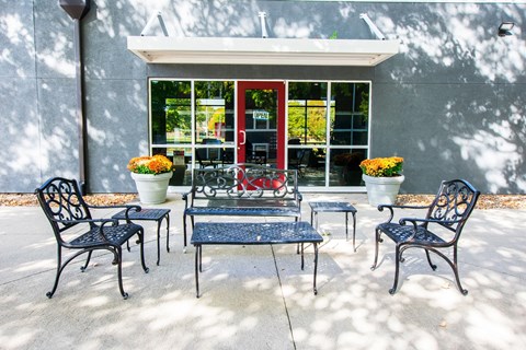 A patio with a table and chairs with a house in the background.