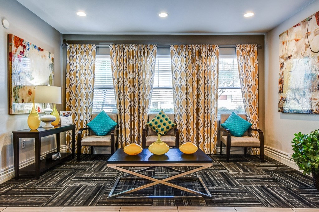 A living room with a black and white patterned carpet and a large window with curtains.
