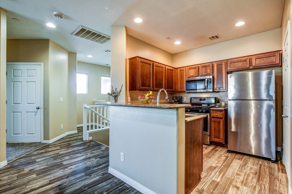 A kitchen with a white fridge and wooden cabinets.