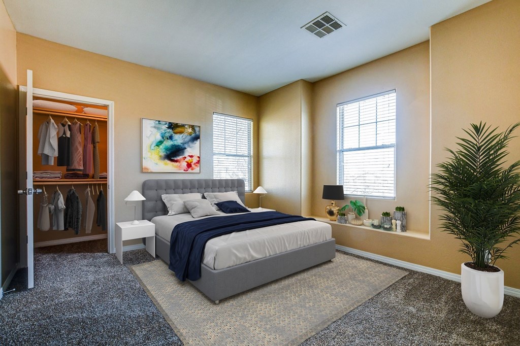 A bedroom with a bed, a plant, and a painting on the wall.