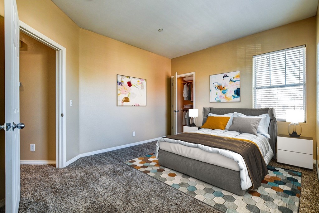 A bedroom with a bed, nightstand, and two pictures on the wall.