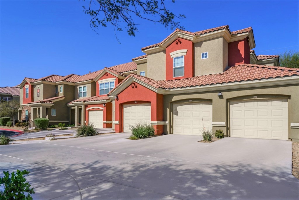 A row of houses with red roofs and garages.