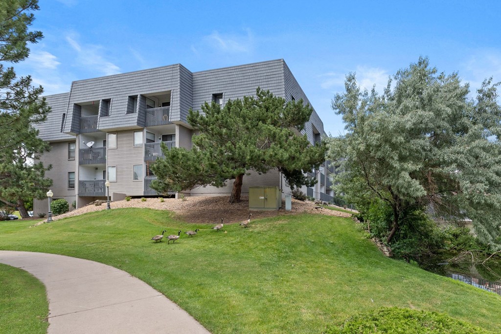 A modern apartment building with a green lawn in front.