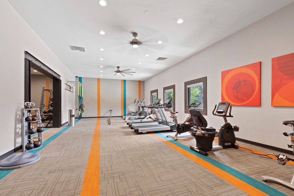 A gym with exercise equipment and a person working out.