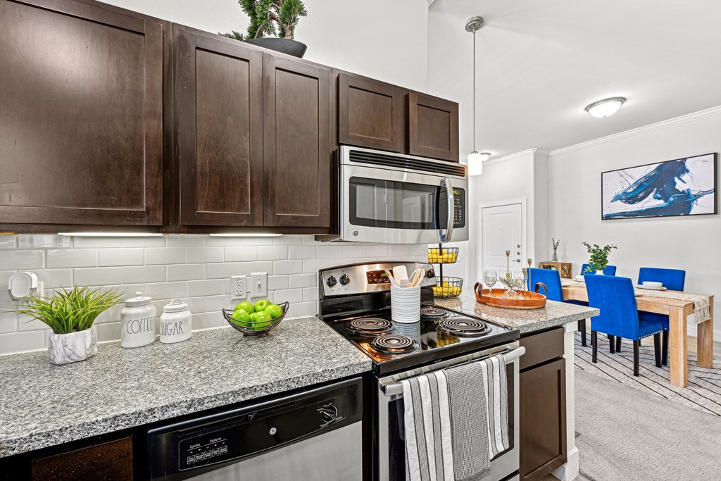 A kitchen with dark brown cabinets and a black stove top.