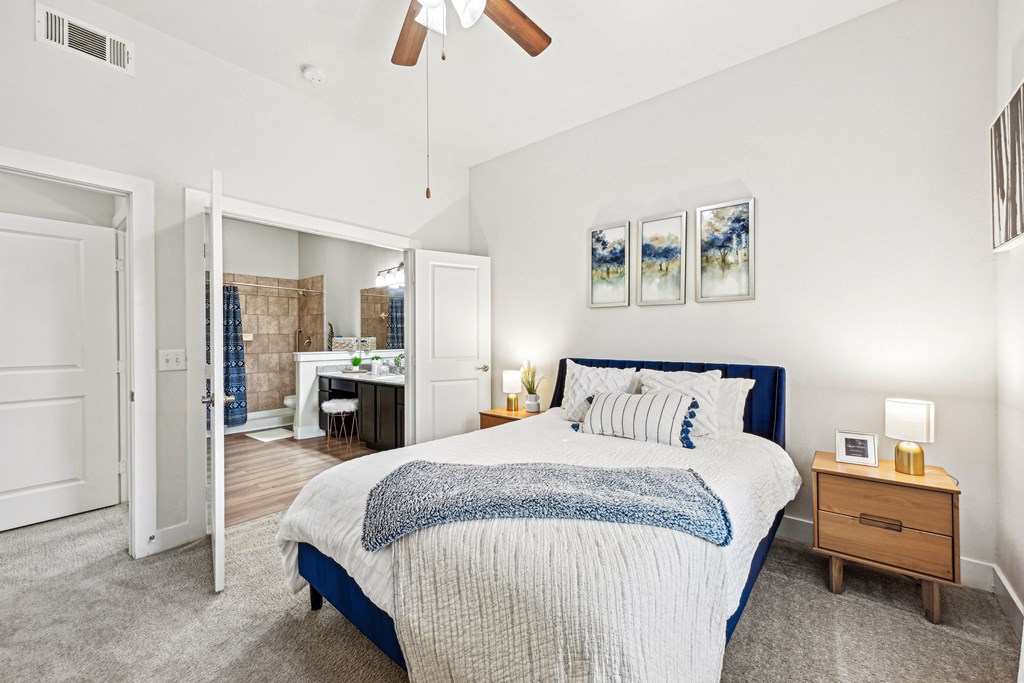 A bedroom with a large bed and a ceiling fan.