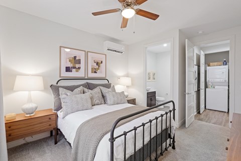 A bedroom with a bed, nightstand, and a ceiling fan.