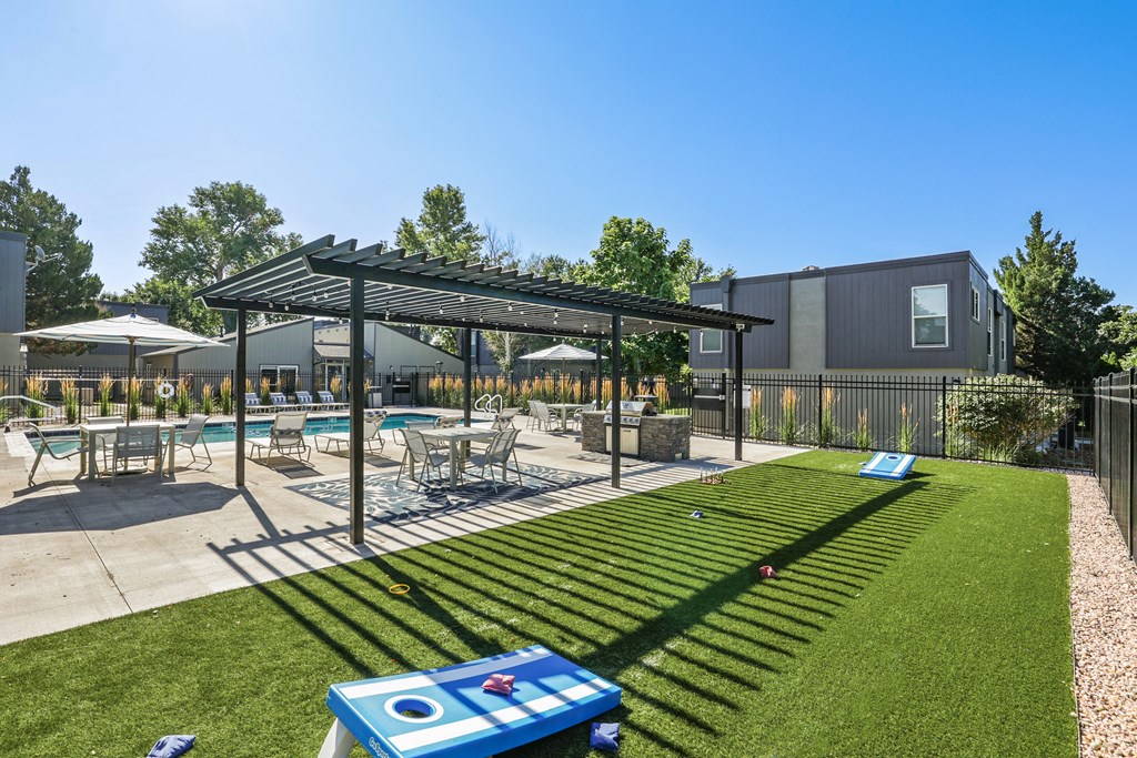 commons pool and patio with tables and umbrellas and lawn games