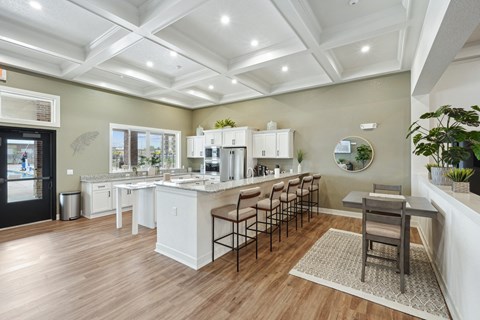 A kitchen with white cabinets and a wooden floor.