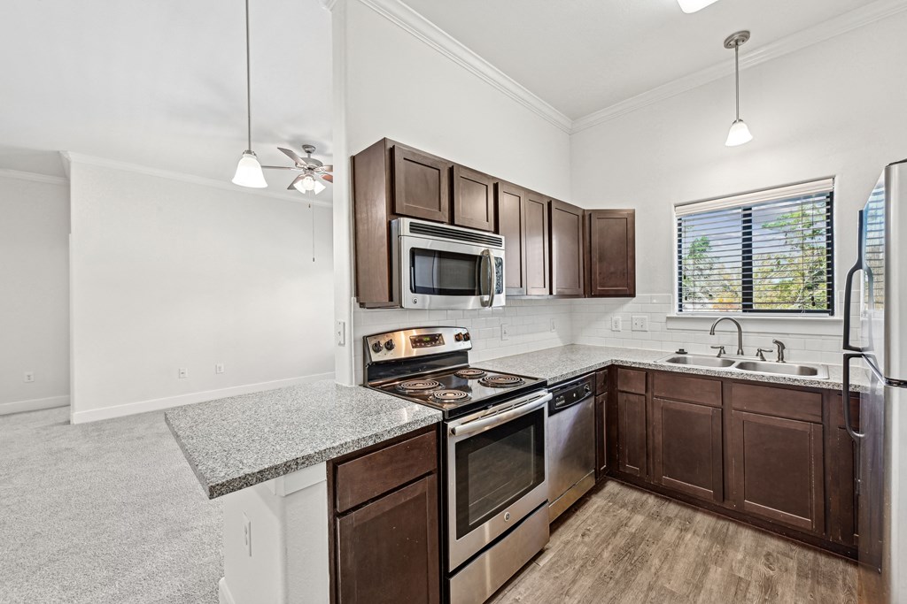 A kitchen with brown cabinets and stainless steel appliances.