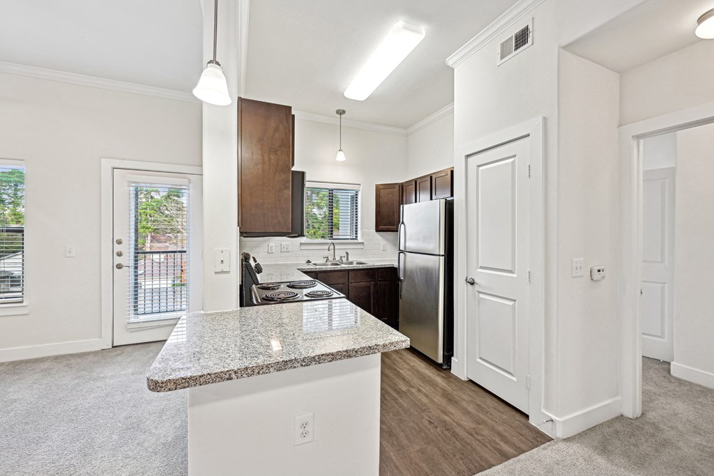 A kitchen with a granite countertop and stainless steel appliances.