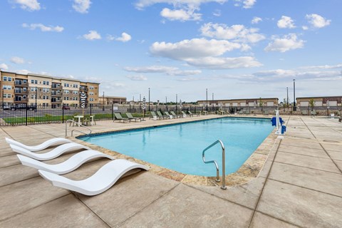 A large outdoor swimming pool with a white wave-like design on the edge.