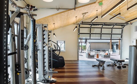 A gym with a variety of equipment including treadmills, weights, and exercise machines.