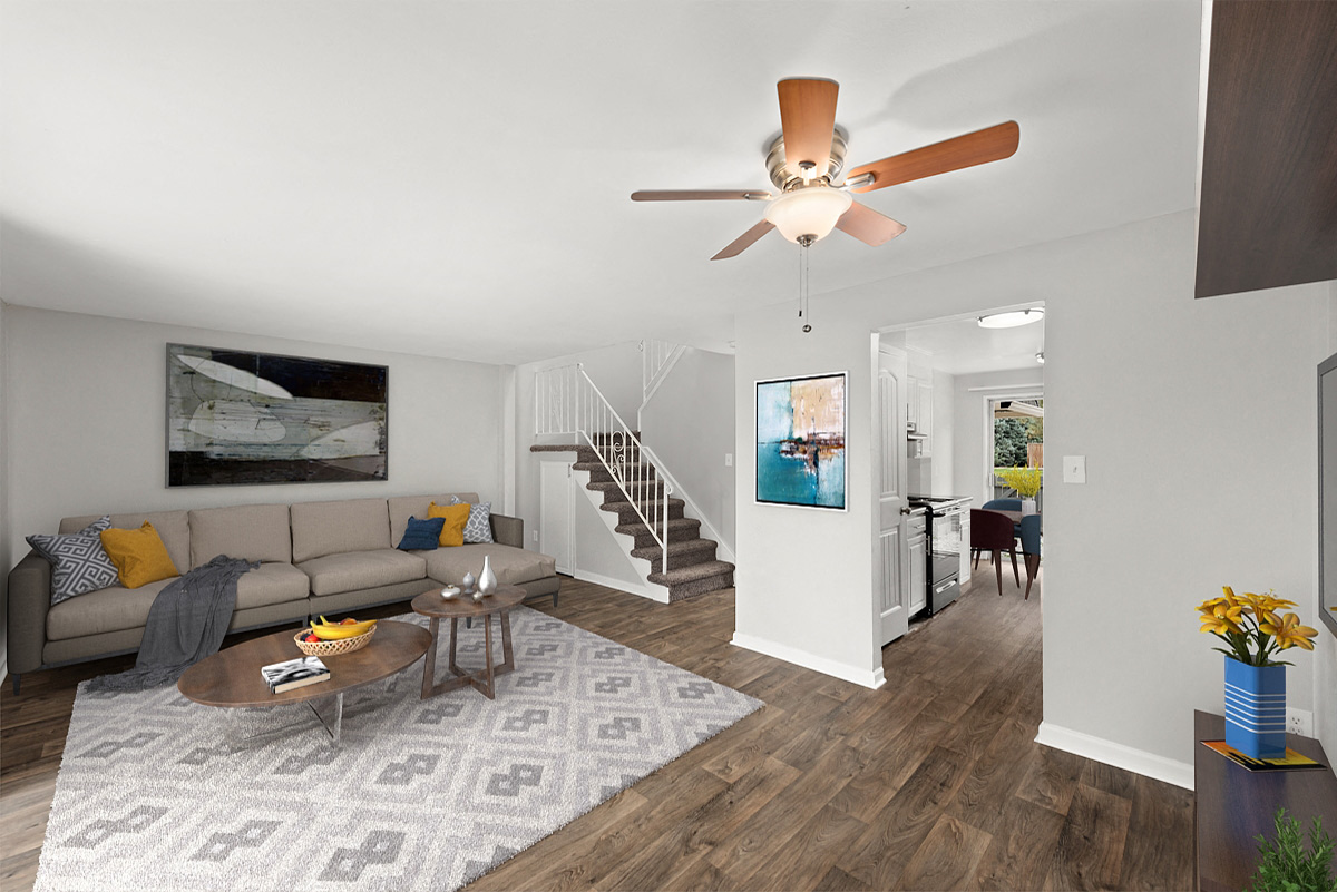 a living room with a couch and a table and a ceiling fan