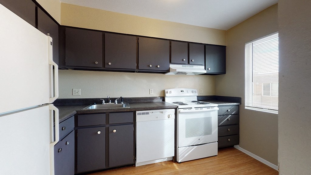 a kitchen with white appliances and black cabinets