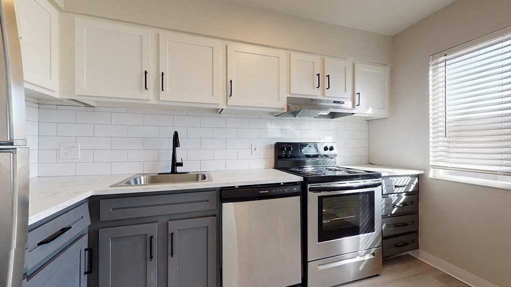 a kitchen with white cabinets and stainless steel appliances