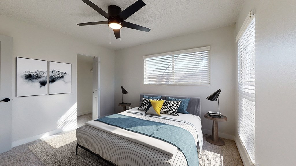a bedroom with a bed and a ceiling fan