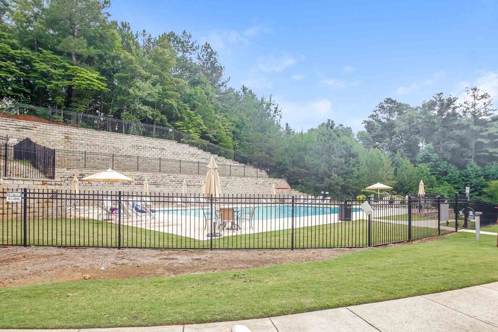 a swimming pool with a wrought iron fence around it