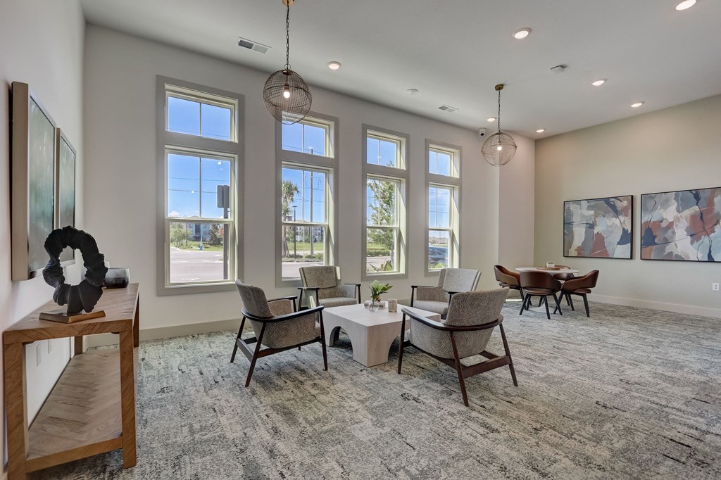 a living room with large windows and a table and chairs