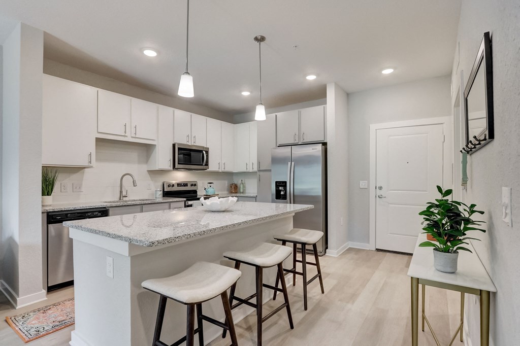 an open kitchen with a large island with bar stools