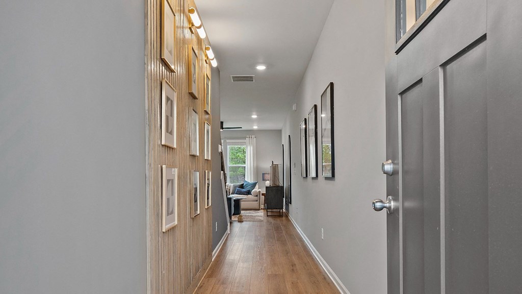 a long hallway with grey walls and wood floors