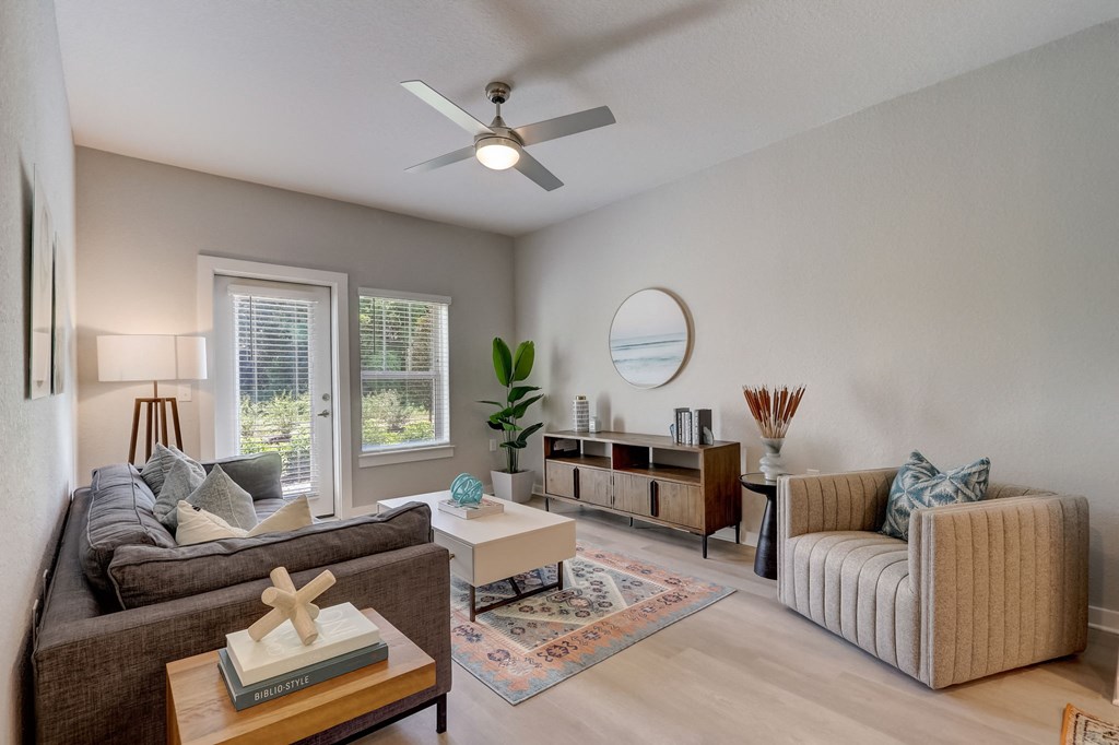 a living room with couches and a coffee table and a ceiling fan
