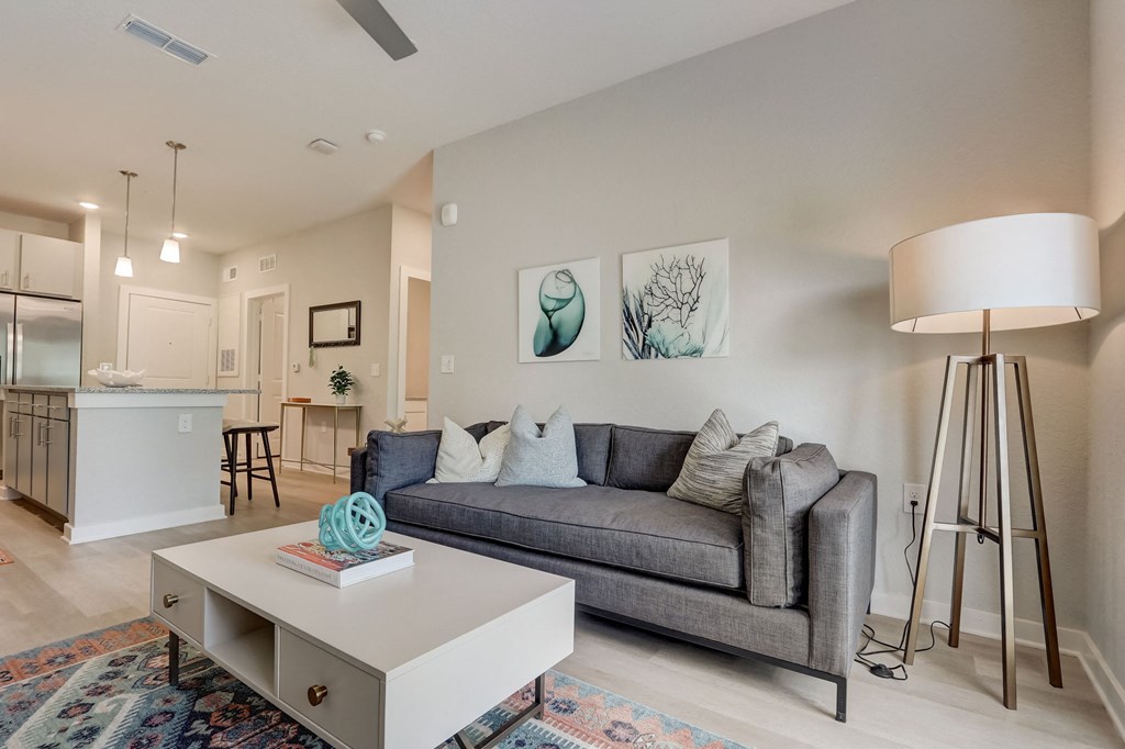 a living room with a gray couch and a white coffee table