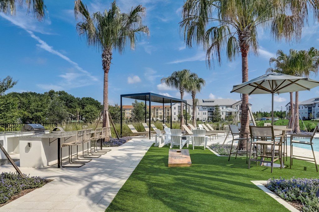 a patio with tables and chairs and palm trees