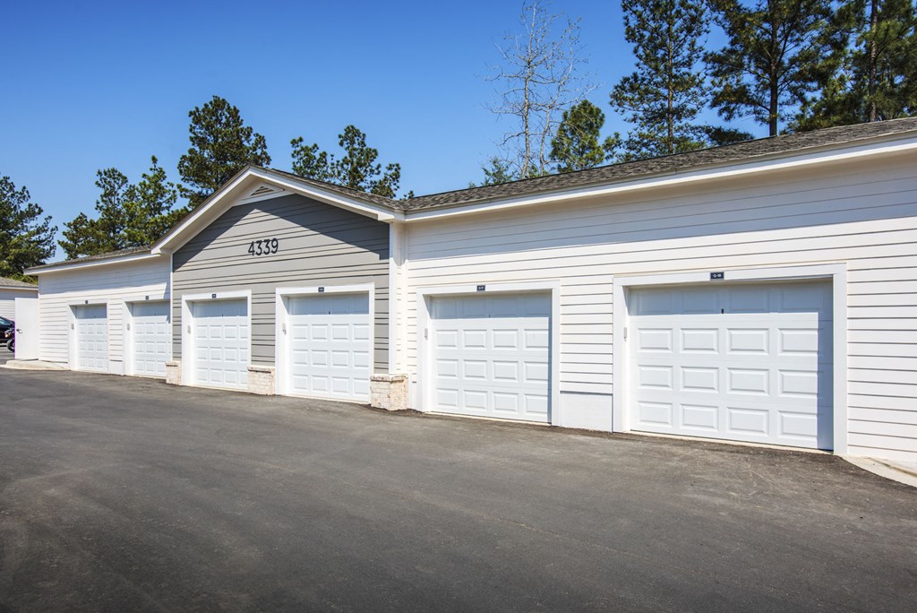 a row of white garage doors on the side of a building