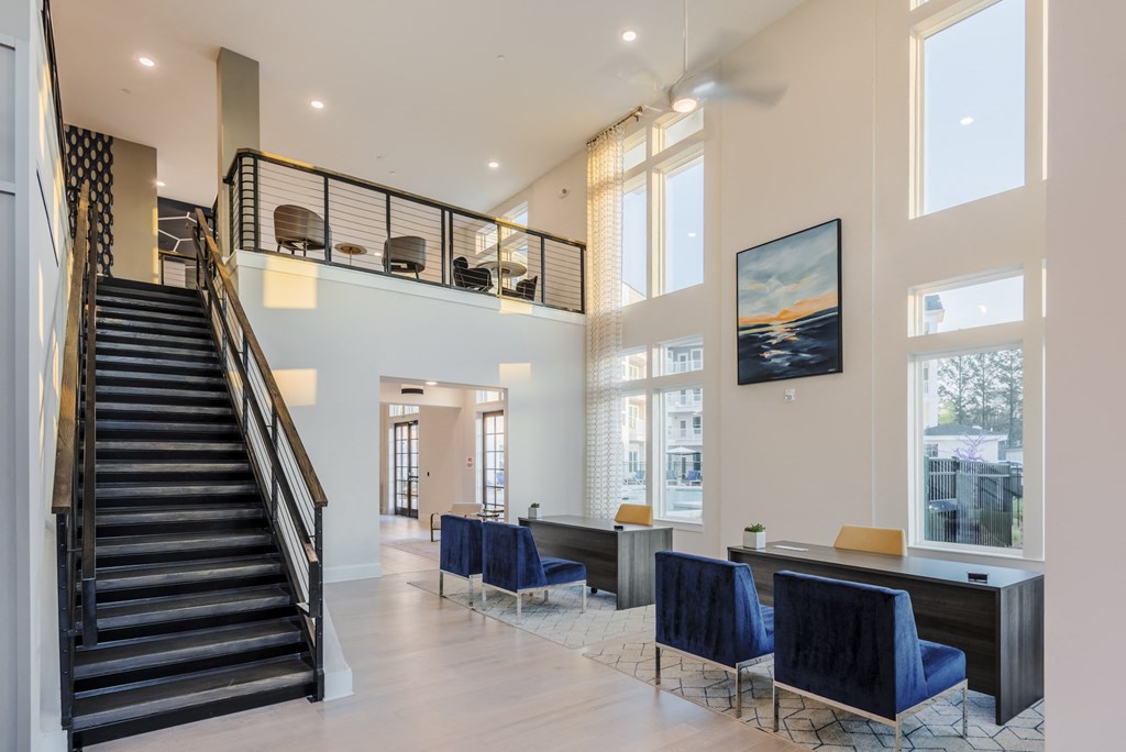 a living room with blue chairs and a staircase