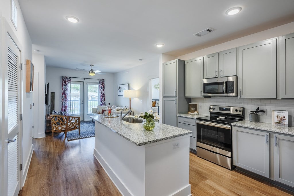 a kitchen with white cabinets and a marble counter top