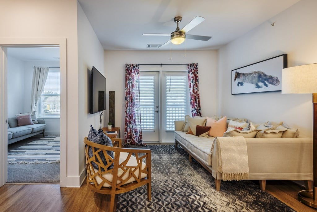 a living room with a couch and a chair and a ceiling fan