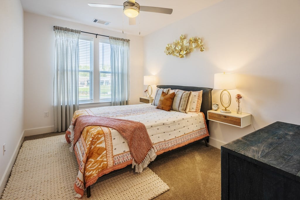 a bedroom with a bed and a ceiling fan