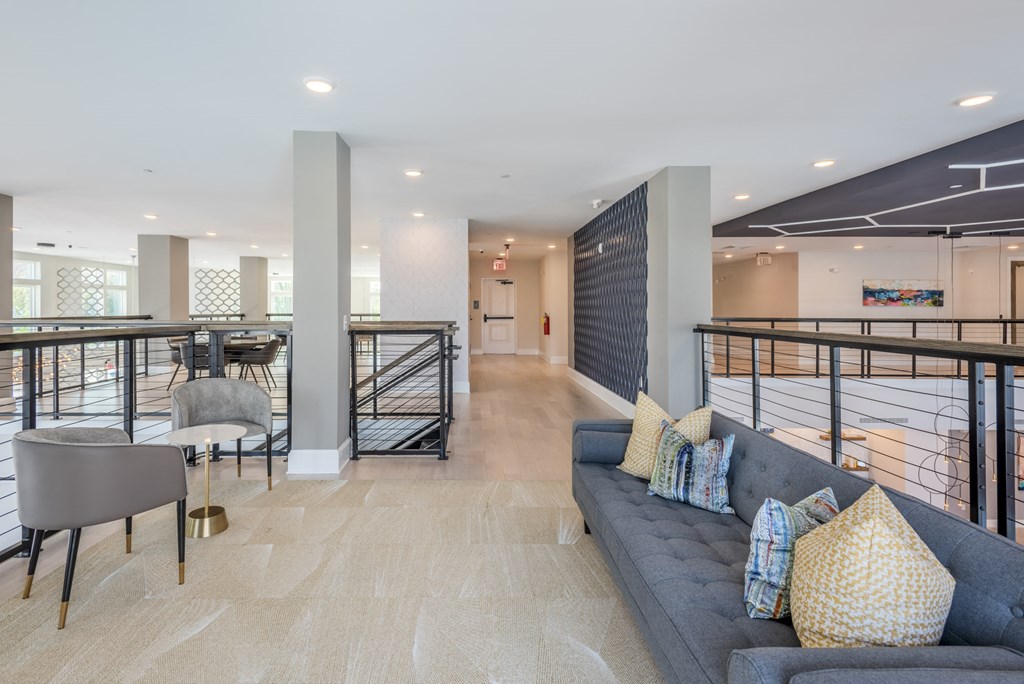 a living room with a gray couch and a table with chairs