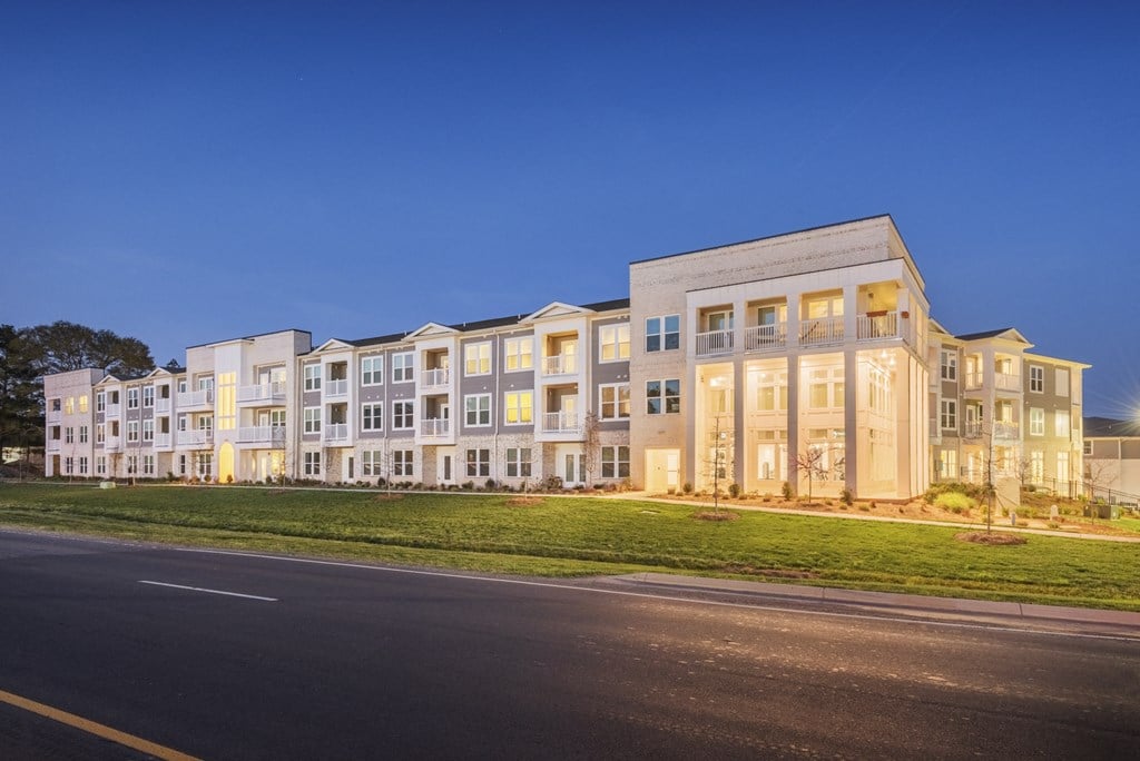 a large apartment building on a city street at night