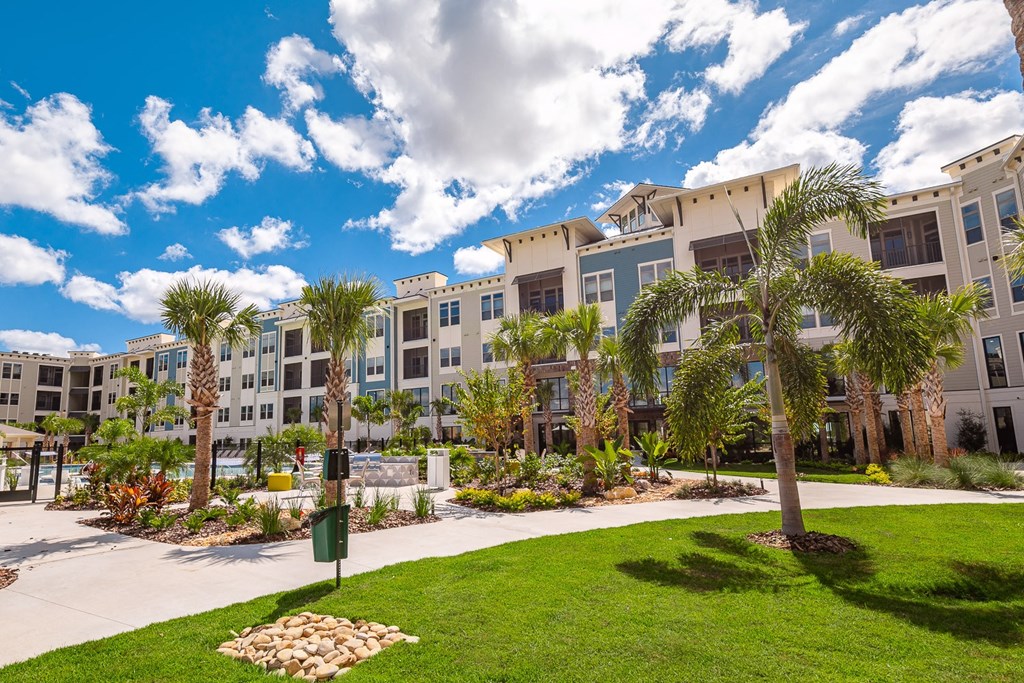a large apartment building with palm trees in front of it