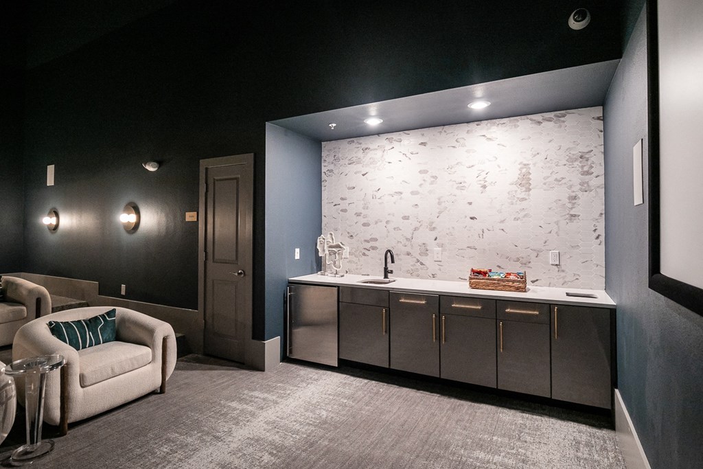 a dark room with a kitchen and a couch