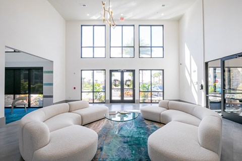 a living room with white couches and a glass coffee table