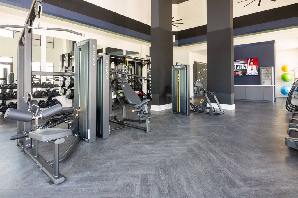 a gym with weights and cardio equipment in a building
