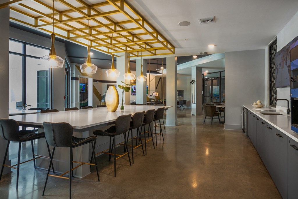 the kitchen and dining area of a house with a long table and chairs