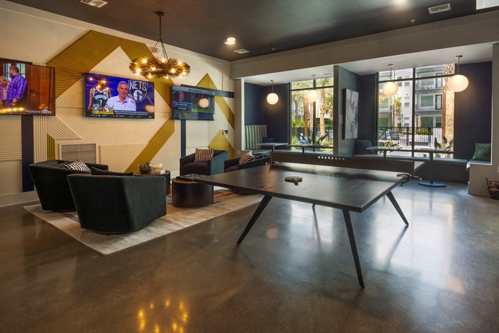 a living room with a ping pong table and a television