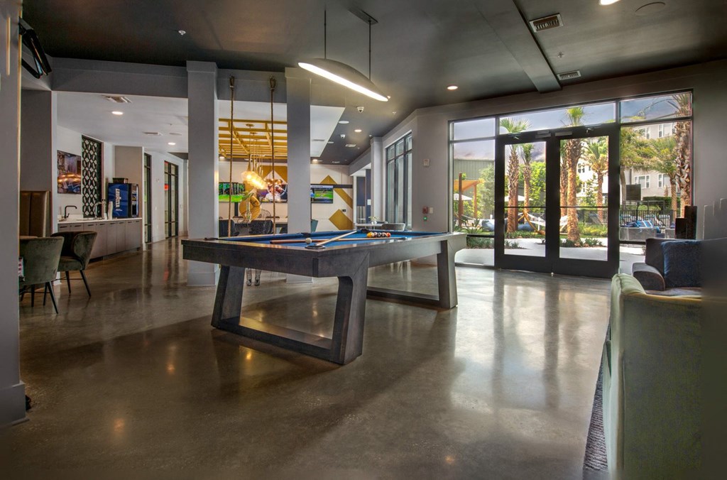 a pool table in the lobby of a house with glass doors