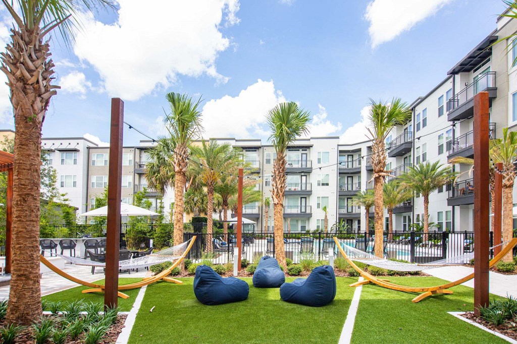 a courtyard with hammocks and palm trees