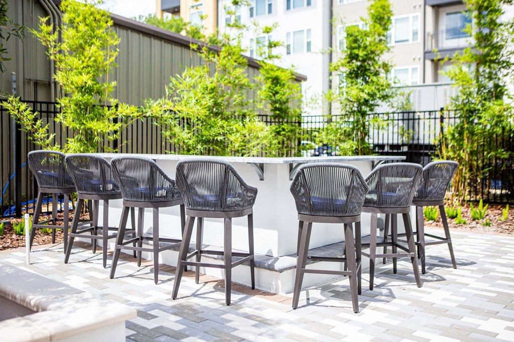 a bar with bar stools and chairs on a patio